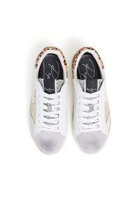 Baltie sporta apavi ar dažādu tekstūru miksu: leopardu raksta aksesuāri, pelēks zamšs, sudraba atstarojošas plāksnes un plakana šņorēšana.