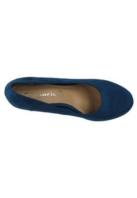Chaussure à enfiler en daim bleu avec un bout arrondi et un intérieur lisse. Présente une empreinte de logo subtile sur la semelle intérieure. Aucun élément métallique ou accent visible.