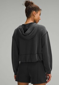 Cropped black hoodie with a drawstring hood, soft fabric, ribbed hem, and long sleeves, paired with matching black shorts.