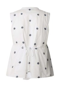 Tunique blanche avec motifs brodés bleu marine, design sans manches, taille ajustable avec cordon, et texture douce.