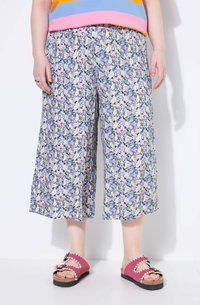 Culotte floreali blu con fiori rosa e gialli, caratterizzati da una vestibilità ampia e una cintura elastica; abbinati a sandali rosa.