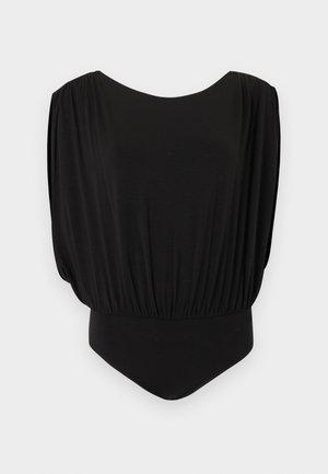 Μαύρο αμάνικο ολόσωμο κορμάκι με φαρδιές, χαλαρές ώμους και εφαρμοστό κάτω μέρος πάνω σε ανοιχτό γκρι φόντο.