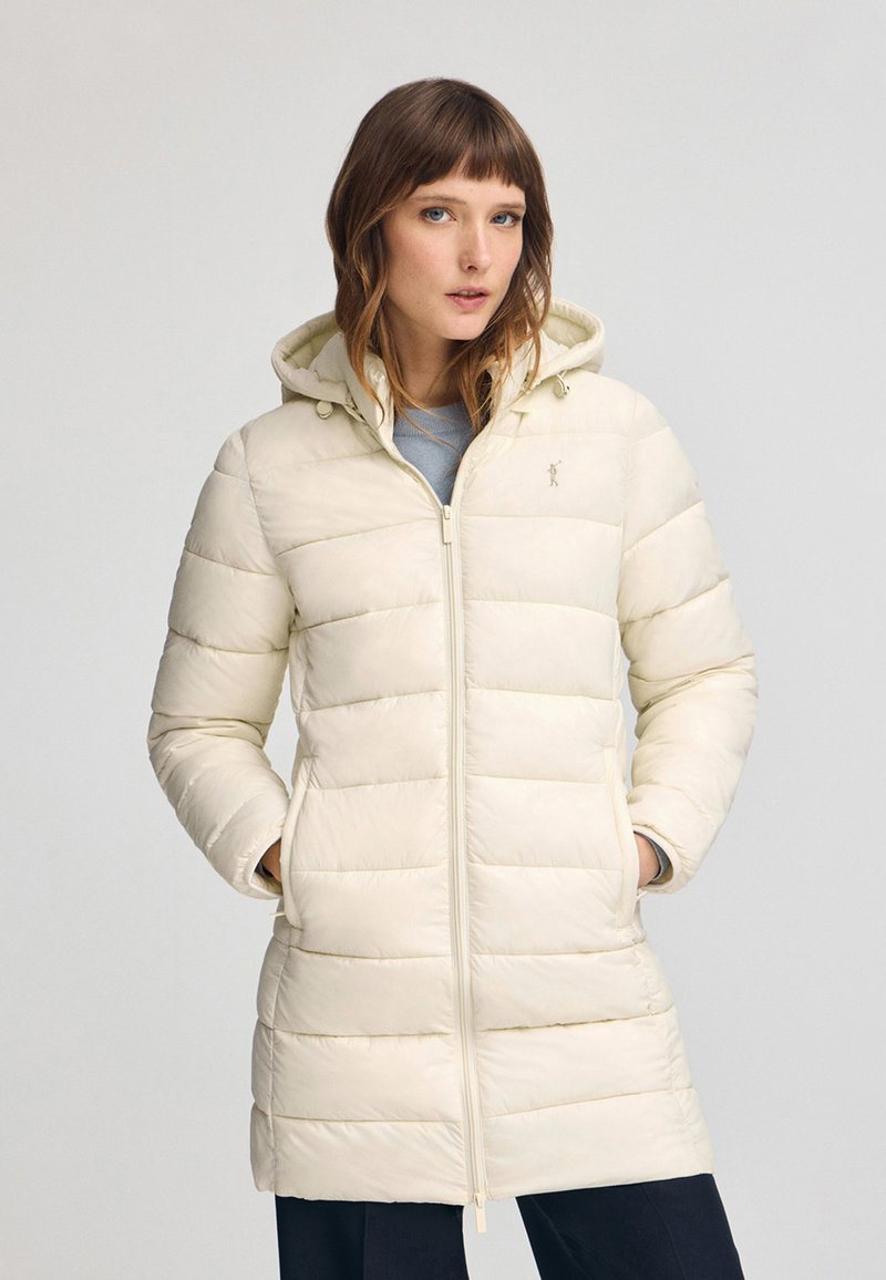 Opvaskjakke i lys creme med hætte, der har lynlås lukning, ribbede manchetter og lodrette baffel-syninger. Minimalistisk design med logo detalje.