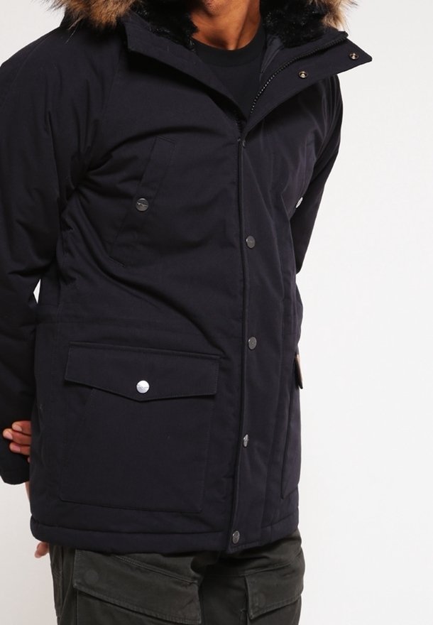 Námořnická modrá zateplená bunda s kapucí lemovanou umělou kožešinou, druky, dvěma předními kapsami a zipem pro teplo a ochranu.