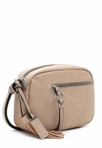 Beige läder crossbody-väska med ett zippered huvudfack, framficka, svart rem och tofsdetalj. Slät textur och minimalistisk design.