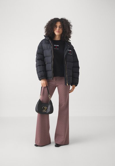 Crni pufasti kaput, oversized kroj, zlatni zip, uparen s crnom duksericom. Smešane karirane široke pantalone i crna torba sa detaljem u obliku srca.