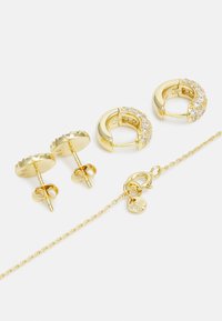 Goldohrringe und -armbandset; umfasst Ohrstecker mit strukturierten Akzenten und Creolen, die mit klaren Kristallen verziert sind, mit einem Karabinerverschluss.