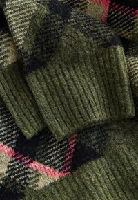 Maglione verde in lana con polsini a coste, caratterizzato da un motivo a quadri in nero, oliva e rosa. Tessuto morbido e strutturato con un aspetto accogliente.