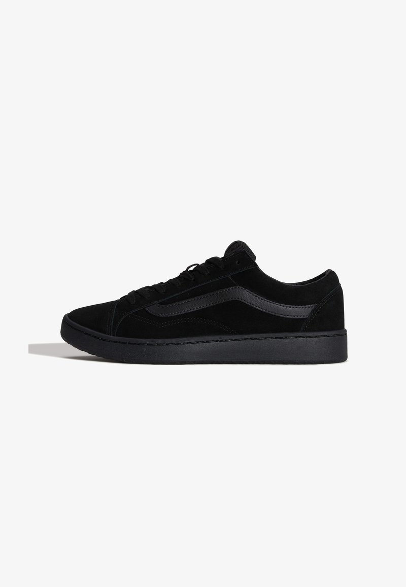 Μαύρο sneaker χαμηλής κοπής με κορδόνια μπροστά, παχιά σόλα και λεπτομέρεια με ρίγα στο πλάι, εμφανιζόμενο από αριστερή πλευρά σε λευκό φόντο.