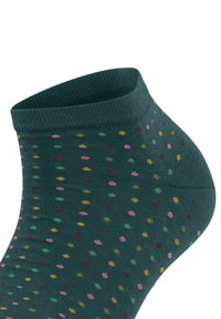 Chaussette verte à la cheville avec une bordure côtelée et un motif à pois multicolores en rose, jaune et vert. Texture douce et ajustement confortable.