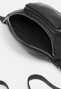 Borsa a tracolla nera in pelle con finitura testurizzata, dotata di un comparto principale e una tasca esterna con zip, entrambi foderati in tessuto.