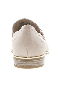 Chaussure en daim beige avec un arrière arrondi, un talon subtil et un accent doré autour de la semelle inférieure, présentant une texture lisse et un design épuré.