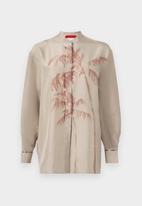 Blusa di satin beige con colletto alla cinese, caratterizzata da una stampa di palme in rosso sbiadito. Maniche lunghe con polsini e chiusura con bottoni sul davanti.