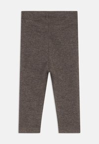 Barna bordázott leggings puha anyagból, rugalmas derékrésszel és testhez simuló fazonnal. Nincsenek további minták vagy díszítések.