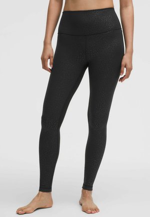 Schwarze dehnbare Leggings mit einem subtilen Leopardenmuster, hoher Taille, figurbetontem Design und Knöchellänge. Weicher, glatter Stoff.