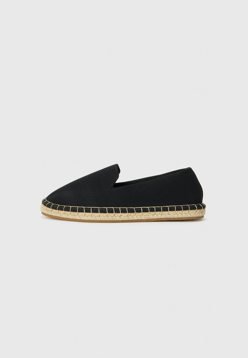 Black slip-on shoe with a textured upper, featuring a jute rope sole and contrasting stitching along the edge, smooth front design.
