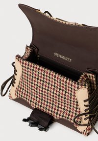Geantă de piele maro cu un model țesut houndstooth în crem și burgundy, dotată cu un buzunar cu fermoar și accente din panglică pe părțile laterale.