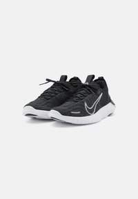 Čierne športové topánky s pletenou textúrou, bielou podrážkou a výrazným logom Nike. Obsahujú šnúrky na zaviazanie a pútko na päte.