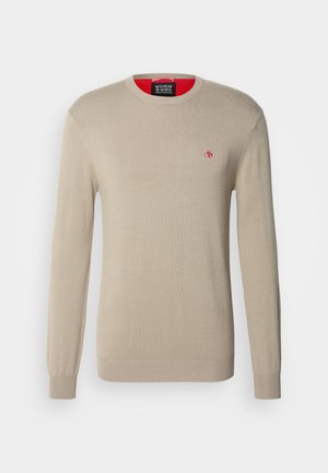 Beige gestrickter Pullover mit langen Ärmeln, rundem Halsausschnitt und einem kleinen roten Logo auf der Brust. Mit gerippten Bündchen und Saum ausgestattet.