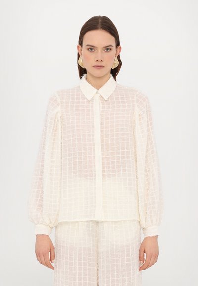 Durchsichtige weiße Bluse mit kariertem Muster, ausgestattet mit einem spitzen Kragen, langen Puffärmeln und einer Knopfleiste vorn.