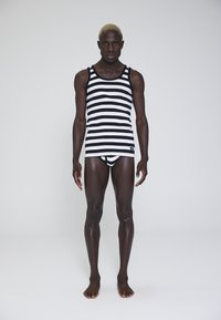 Sort og hvid stribet tanktop, tætsiddende design, med matchende trusser. Glat tekstur, ærmeløs stil, og uden synlige logoer.