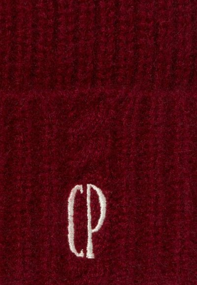 Gorro de punto burdeos con textura acanalada, que presenta un logo bordado en blanco "CP" en la parte frontal. Material de lana suave.