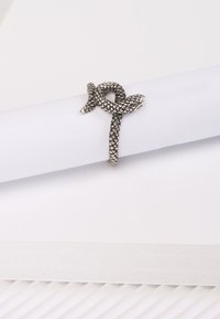 Silberner ring in Schlangenform mit einem strukturierten, verflochtenen Design. Der Ring wird glatt gefertigt und weist detaillierte Schuppen entlang des Schlangen Körpers auf.