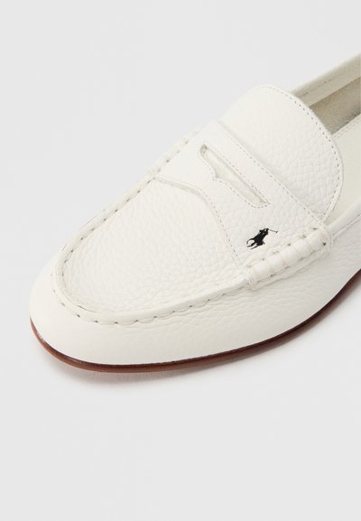 Biela kožená mokasína s textúrovaným povrchom, ktorá má prešitý nárt, výrez a čierny logotyp na boku.