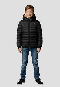 Czarna pikowana kurtka puchowa z kapturem, z zamkiem z przodu, przeszywana, z naszywką z logo na piersi, noszona na niebieskich dżinsach i czarnych sneakersach.