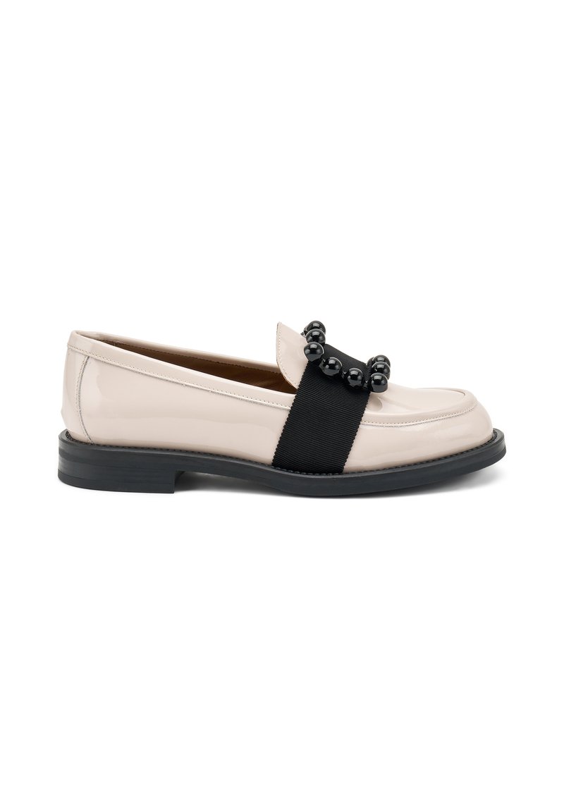 Mocassino in pelle rosa pallido con una fascia elastica nera e dettagli rotondi neri sulla tomaia. Tacco basso in gomma nera e texture liscia.
