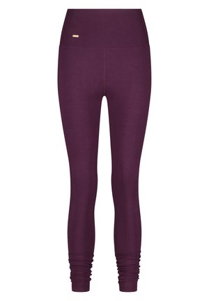 Lila Leggings mit hohem Bund, aus dehnbarem Material gefertigt. Mit gerafften Bündchen an den Knöcheln und einem goldenen Logodetail am Bund.