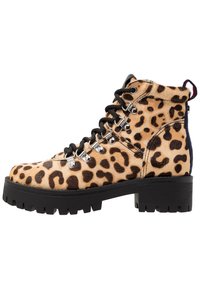 Bottines à imprimé léopard en fausse fourrure, avec des lacets noirs, des œillets métalliques et une semelle noire épaisse avec un motif de relief.