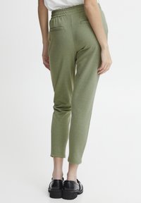 Lichtgroene, stretch joggingbroek met een elastische tailleband en twee achterzakken, met een taps toelopend ontwerp. Vriendelijke textuur.