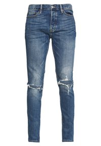 Jeans de mezclilla azul de corte slim con desgarros en ambas rodillas y estilo clásico de cinco bolsillos.