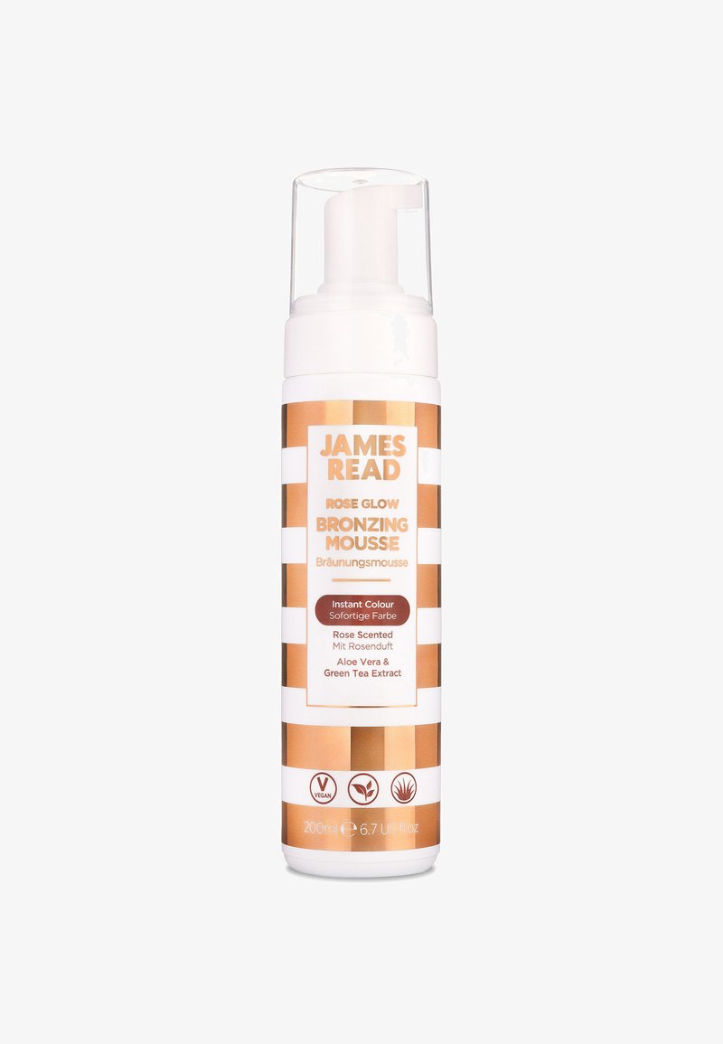 Bronzing-Mousse in einer weiß-gold gestreiften Flasche. Mit Pumpenspender und Etiketten in Englisch und Deutsch. Enthält Aloe Vera und grünen Tee-Extrakt.
