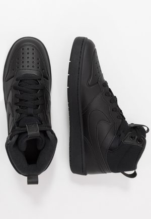 Een paar zwarte hoge sportsneakers met geperforeerde neus, veters aan de voorkant en gevoerde enkels op een witte achtergrond.