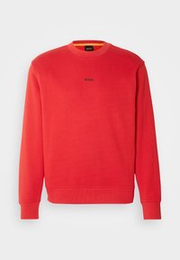 Sweatshirt rouge à manches longues avec col rond, poignets et ourlet côtelés, arborant un petit logo "BOSS" centré sur la poitrine.