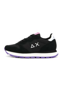Black sneaker with suede and mesh materials, white accents, purple sole, and geometric patterns on the sides. Features round laces and padded collar.