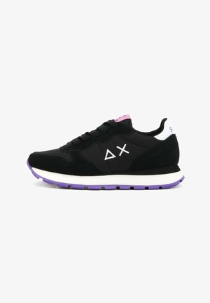 Black sneaker with suede and mesh materials, white accents, purple sole, and geometric patterns on the sides. Features round laces and padded collar.