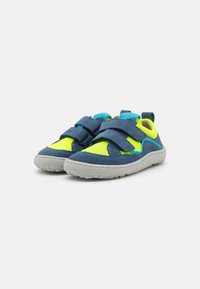 Chaussures de sport bleues et jaune fluo en matériaux en maille et en daim, dotées de deux sangles Velcro et de semelles en caoutchouc pour une meilleure adhérence.