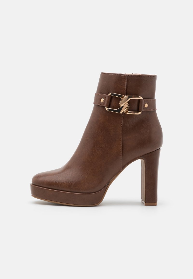 Bottine marron à talon haut avec semelle plateforme et bride décorative à boucle dorée sur le côté, texture cuir lisse.