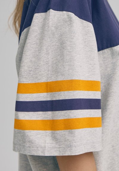 Cămașă cu mânecă scurtă, având un corp gri și dungi orizontale albastre și galbene pe mâneci, realizată dintr-un material moale și texturat.