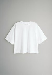 Weißes Baumwoll-T-Shirt mit lockerem Schnitt, kurzen Ärmeln und einem rundem Halsausschnitt. Glatte Textur und minimalistisches Design. Keine sichtbaren Muster oder Akzente.