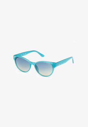 Un par de gafas de sol de plástico turquesa con lentes ovalados, tinte degradado y adornos de tachuelas en las patillas.