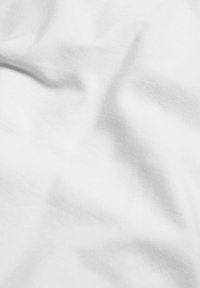 Tessuto di cotone bianco con una texture liscia, che presenta lievi pieghe e grinze, mettendo in risalto la sua natura morbida e flessibile.