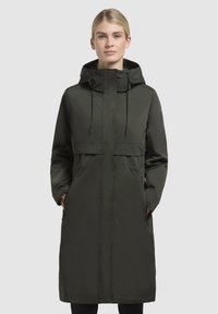Long dark green coat with a hood, featuring a cinched waist, front pockets, and a smooth, water-resistant fabric.