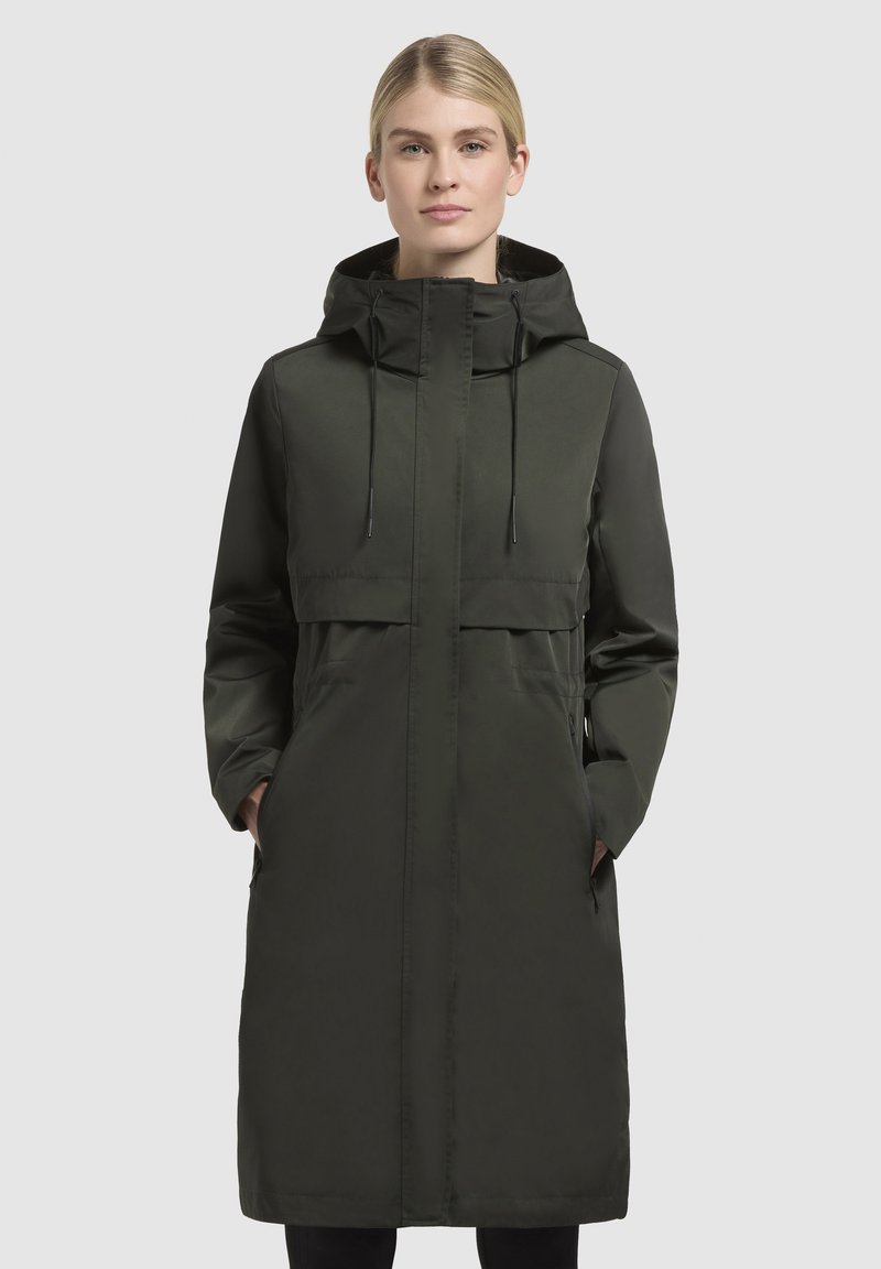Long dark green coat with a hood, featuring a cinched waist, front pockets, and a smooth, water-resistant fabric.
