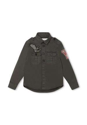 Mørkegrøn skjorte med knapper foran og lange ærmer. Har to forlommer, skulderstropper og broderede fugle- og bogstavs-mærker.