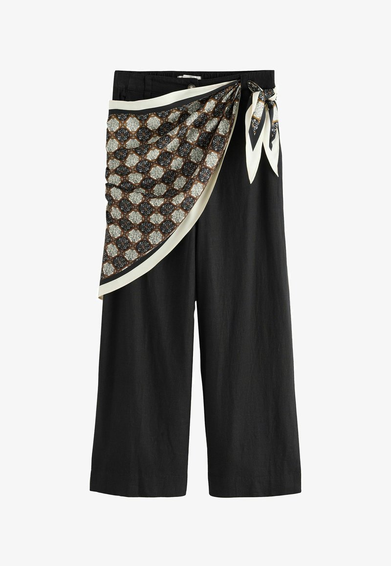 Pantalon noir à jambes larges avec une écharpe à motifs nouée à la taille, présentant des formes géométriques en noir, blanc et marron.