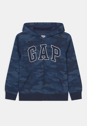 Marineblå hættetrøje med camouflageprint, med "GAP"-logo i hvid, kængurulommer og ribbede manchetter og kant.